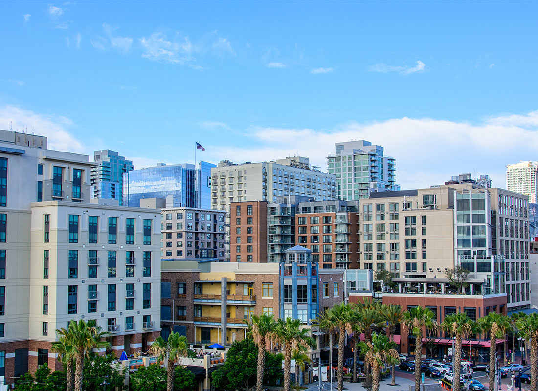 Insurance Solutions - View of Commnercial Buildings Surrounded by Palm Trees Against a Cloudy Blue Sky in Downtown San Diego California